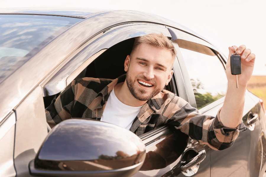 mann mit auto und schlüssel in der hand